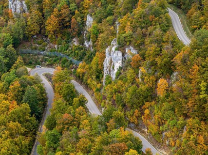 Swabian Alb in autumn, Albtrauf with colourful mixed forest and winding country road. Bad Urach,