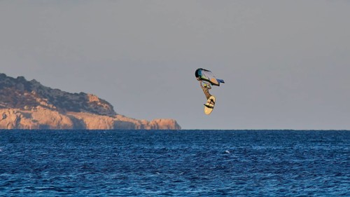Wingfoiller, surfer in the air over the sea near a coast with cliffs, windsurfer, Meltemi