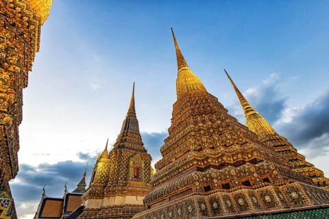Wat Pho temple at sunset. Bangkok's oldest Buddhist monastery near the Grand Palace. Four chedis