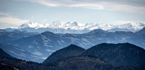 View of the Alpine foothills and main Alpine ridge with snow-covered peaks, summit of the Hohe