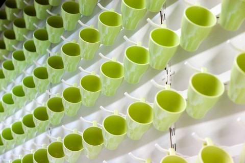 Green drinking cups hanging in an IKEA store create abstract pattern