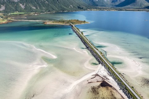 Aerial view of a bridge over turquoise sea at a sandy beach, fjord Grunnforfjorden, Lofoten