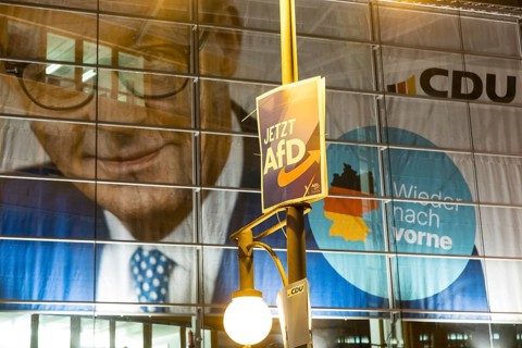 Banner with the likeness of Friedrich Merz behind an AfD election poster (now AfD) at the