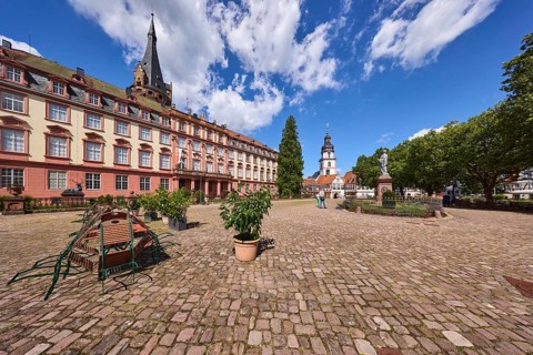 Erbach Castle, outdoor area with tables and chairs, flower pots, trees, monument to Count Franz,