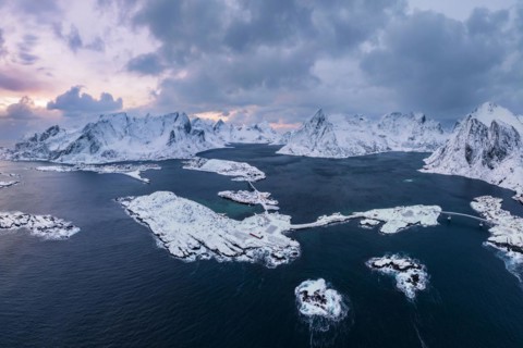 View of snow-covered islands, fjord and mountains, fishing villages Sakrisøy and Reine, Reinefjord,
