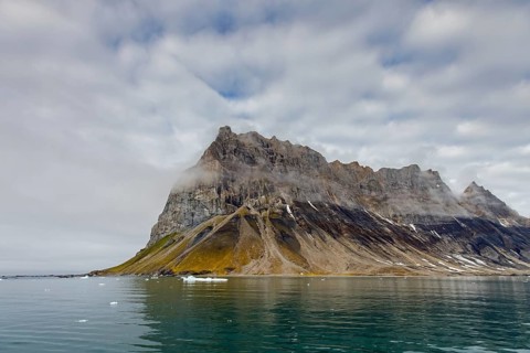 Gnalberget, mountain with steep sea cliffs in Hornsund fjord at Gnålodden in summer, Svalbard,