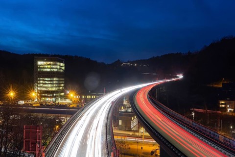 Federal road B14 at night, road bridge with traffic and light lanes. On the left the building of
