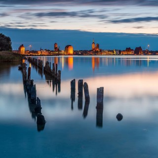 View at dusk over the Strelasund to the illuminated town of Stralsund with its churches and the