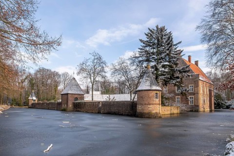 Moated castle Haus Welbergen surrounded by frozen water and snow-covered trees, Ochtrup-Welbergen,