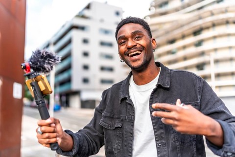 Handsome young african male influencer vlogging while walking along the city