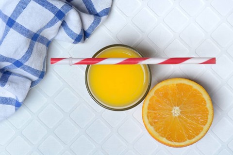 Orange juice in glass and orange, straw