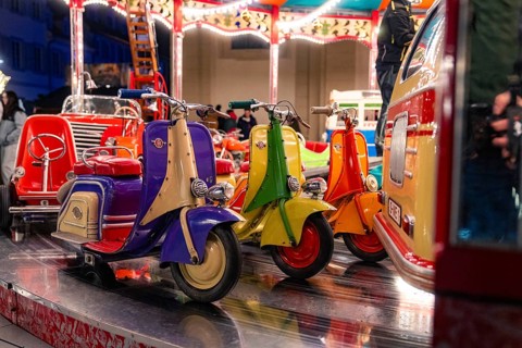 Colourful toy scooters on a fairground carousel at night, Christmas market Ludwigsburg, Germany,