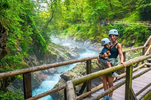 Mother carrying her child while visiting the stunning vintgar gorge near bled, slovenia, enjoying a