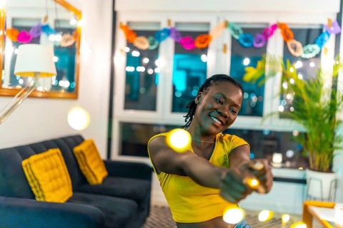 Portrait with copy space of a cool african woman dancing during night home party