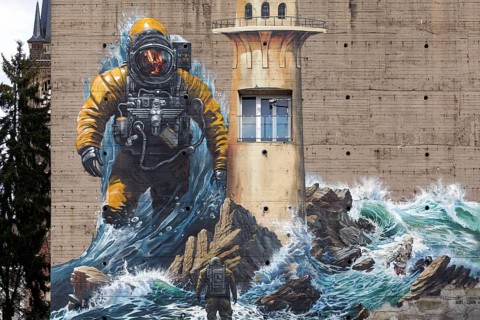Astronaut standing in surf, mural on the subject of climate change on a bunker, by street art