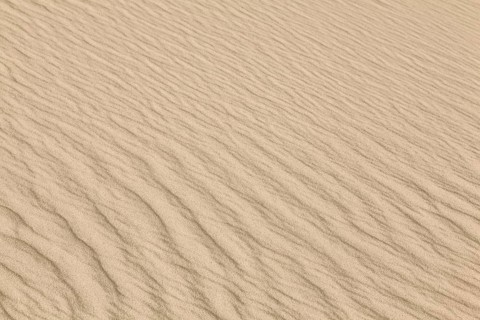Close-up of sandy dunes with wave-like patterns and a warm, beige colour scheme, Sankt