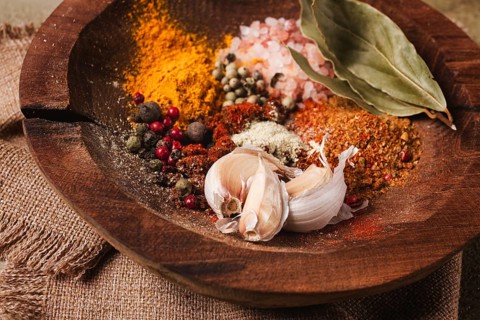 Spice mix, garlic and bay leaf, on a wooden plate, close-up, food concept, no people