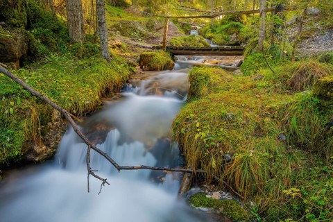 View of a wooden bridge leading over a torrent, long exposure, Dolomites, Puez-Geisler nature park