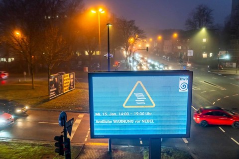 Dense fog, with visibility partly below 100 metres, city centre traffic at rush hour on