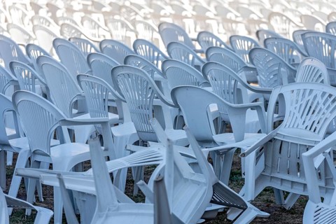 Seating for outdoor event, rows of chairs, overturned garden chairs made of plastic, plastic,