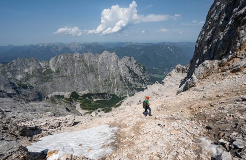 Mountaineer with helmet in rocky mountain landscape, descent to the Grieskarscharte, crossing the