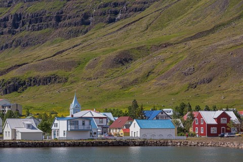 Blue and red houses in Seydisfjordur village on a bright sunny day. E Iceland
