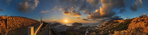 360° panoramic image of an enchanting sunset over the coastal landscape with the town of Arkasa,