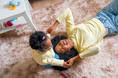 Top view of african mother and toddler playing on the floor