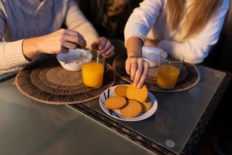 Couple having breakfast together, enjoying orange juice and biscuits, starting their day with a