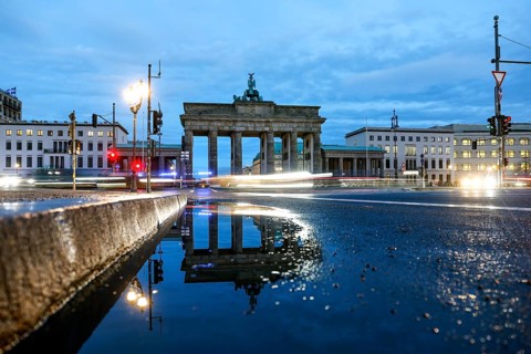 The Brandenburg Tor is reflected in a puddle, cars with lights switched on, Berlin, 27.01.2025,