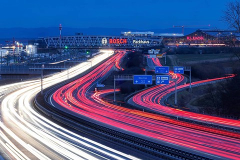 A8 motorway at Stuttgart Airport in the evening. Heavy traffic, lanes of light. Modern architecture