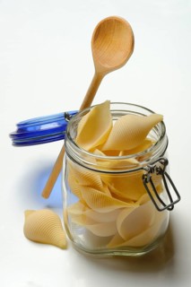 Conchiglione in glass jar with cooking spoon, Italian pasta variety