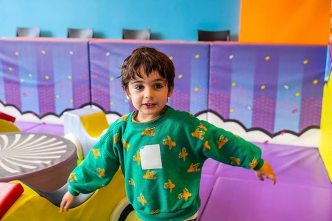 Preschooler enjoying playtime in a vibrant and stimulating indoor play area, promoting early