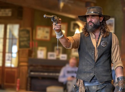 Western actor (sheriff with colt) in the saloon of the western village Fort Bravo or Texas