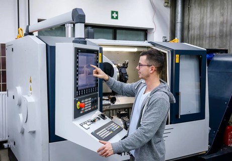 Remscheid, North Rhine-Westphalia, Germany - Trainee in metalworking, here at a CNC machine tool,