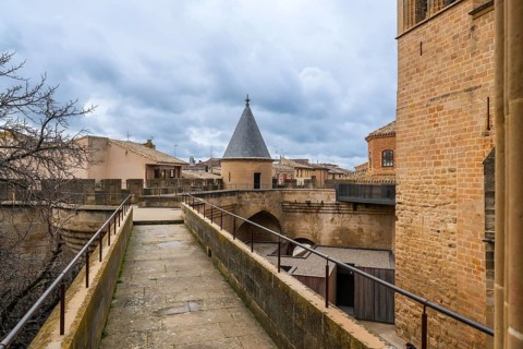 Stone walkway and watchtower rising above the rooftops of olite, offering breathtaking views of the
