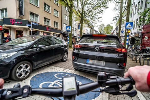 Cycling in the city, inner-city street, cycle lane, bicycles have priority, two-lane traffic with