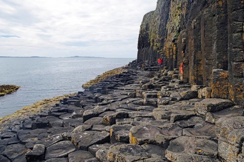 Majestic rock formation with basalt columns on a rugged coastline by the sea, Staffa, Hebrides,