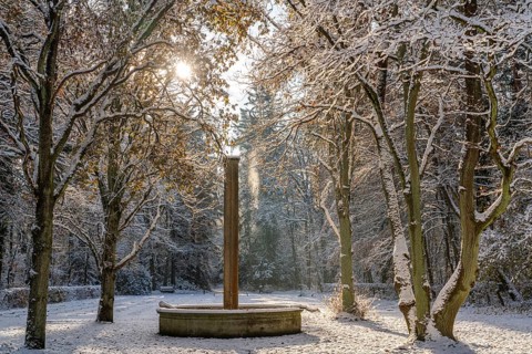 Fountain and snow-covered trees in the sunlight, south-west churchyard, historic cemetery in