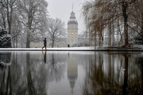 Karlsruhe castle reflected in a pond in the castle garden, Karlsruhe, Baden-Württemberg, Germany,