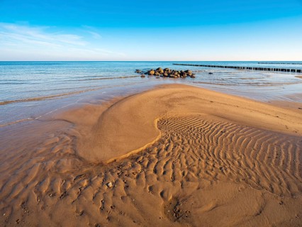 Pristine beach on the Baltic Sea with groynes, sandbank, boulders and sand ripples, Baltic resort