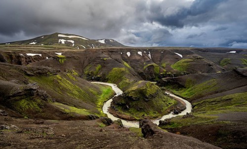 River bend, foot Asgardsa, volcanic landscape with black rocks and green moss, dramatic cloudy sky,