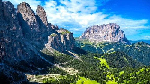 Breathtaking summer landscape in the dolomites, featuring a winding road through lush green valleys