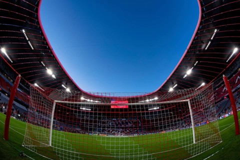 Overview, interior, floodlit match, behind-the-goal perspective, goal net, blue hour, fisheye shot,