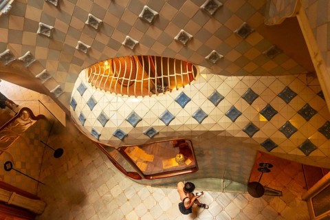 High angle view of a tourist capturing the colorful ceramic tiles and curved staircase design