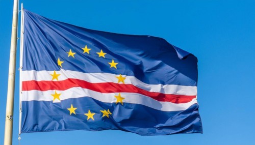 The flag of Cape Verde flutters in the wind, isolated against a blue sky