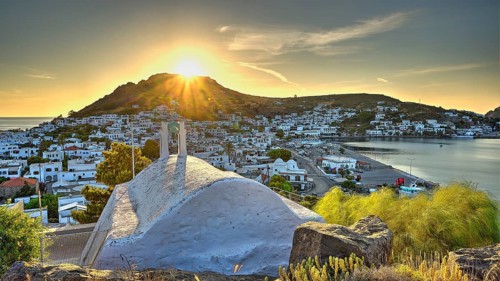 Agia Paraskevi Chapel, Small chapel at sunset with a view of a coastal town and the sea in the