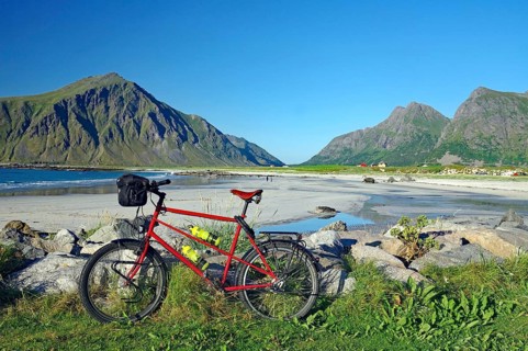 A bicycle on the beach with a view of the surrounding mountains and the sea, Flakstad, Lofoten,