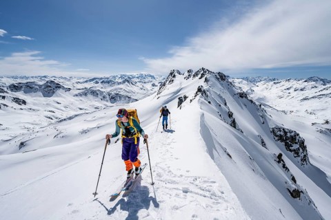 Two ski tourers on a mountain ridge, mountain landscape with snow, mountain panorama with peaks of