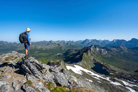 View of mountain landscape, mountain panorama, mountaineer at the summit of Rundfjellet, lake